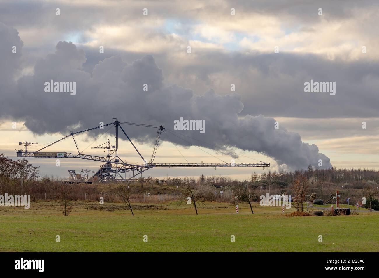 Blick auf einen riesigen Überladestapler vor einem dampfenden Kraftwerk Stockfoto