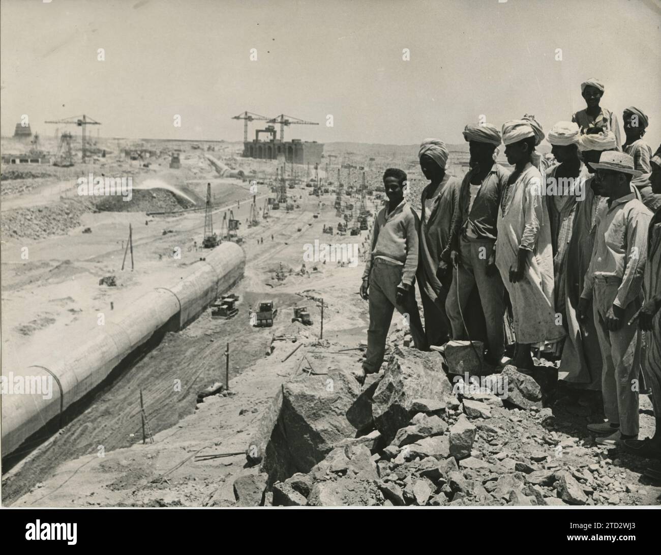 Assuan (Ägypten), Mai 1966. Mehrere ägyptische „Fellahs“ betrachten im Aadd-al-Aall-Gebiet den aktuellen Stand der Arbeiten am Assuan-Damm, in dem bekanntlich Hunderte von Arbeitern aus allen Ländern tätig sind. Quelle: Album / Archivo ABC / Fotofiel Stockfoto