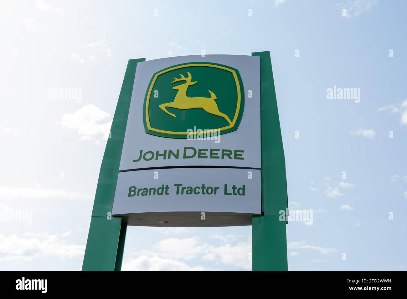 Logo und Schild von John Deere und Brandt Tractor Ltd. Mit blauem Himmel. Calgary, Alberta, Kanada Stockfoto