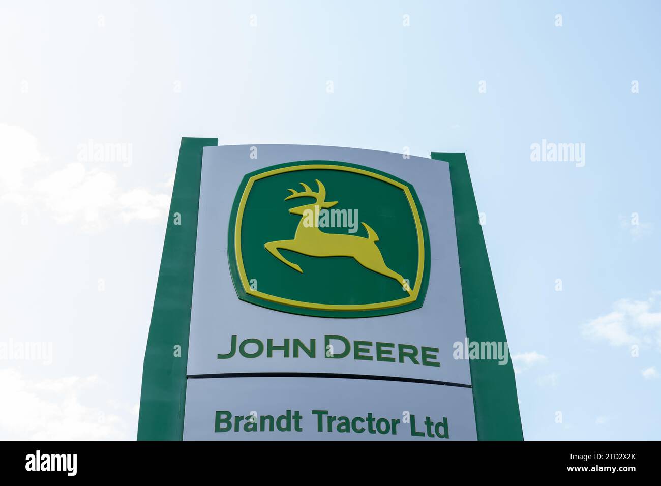 Logo und Schild von John Deere und Brandt Tractor Ltd. Mit blauem Himmel. Calgary, Alberta, Kanada Stockfoto