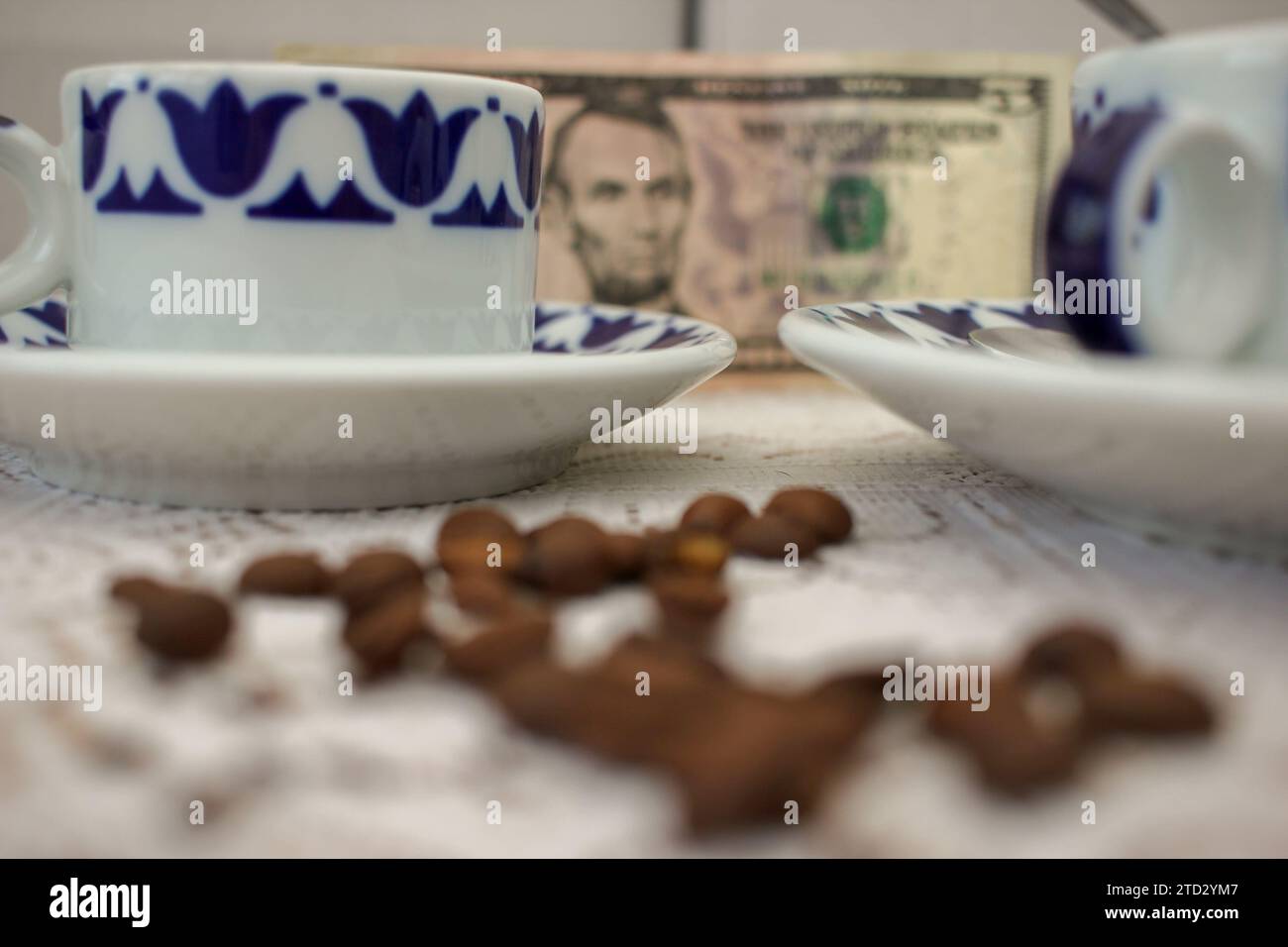 Koffeinkosten: Kaffeetassen Inmitten Teurer Kaffeebohnen Stockfoto