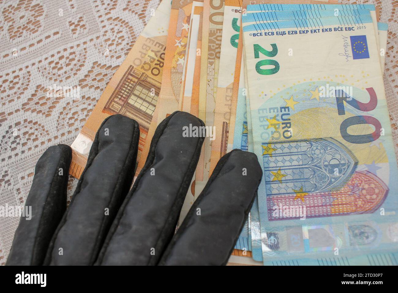 Währungsverbindung: Handschuhe und Euro-Banknoten Stockfoto