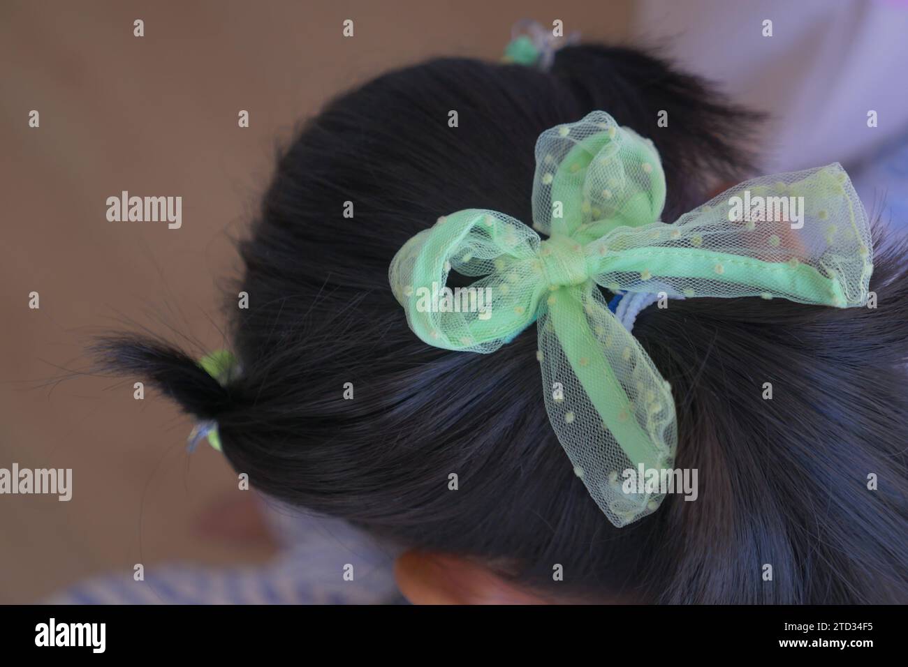 Ein schönes Band ist an ein Kinderhaar gebunden Stockfoto