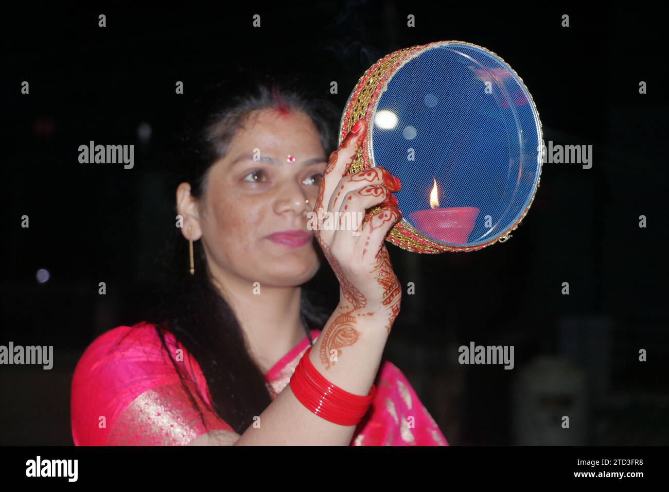 Eine Frau schaut durch das Sieb auf den Mond. Dehradun. Uttarakhand. Indien. Asien. Stockfoto Eine Frau schaut durch das Sieb auf den Mond. Dehradun. Uttarakhand. Indien. Asien. Stockfoto