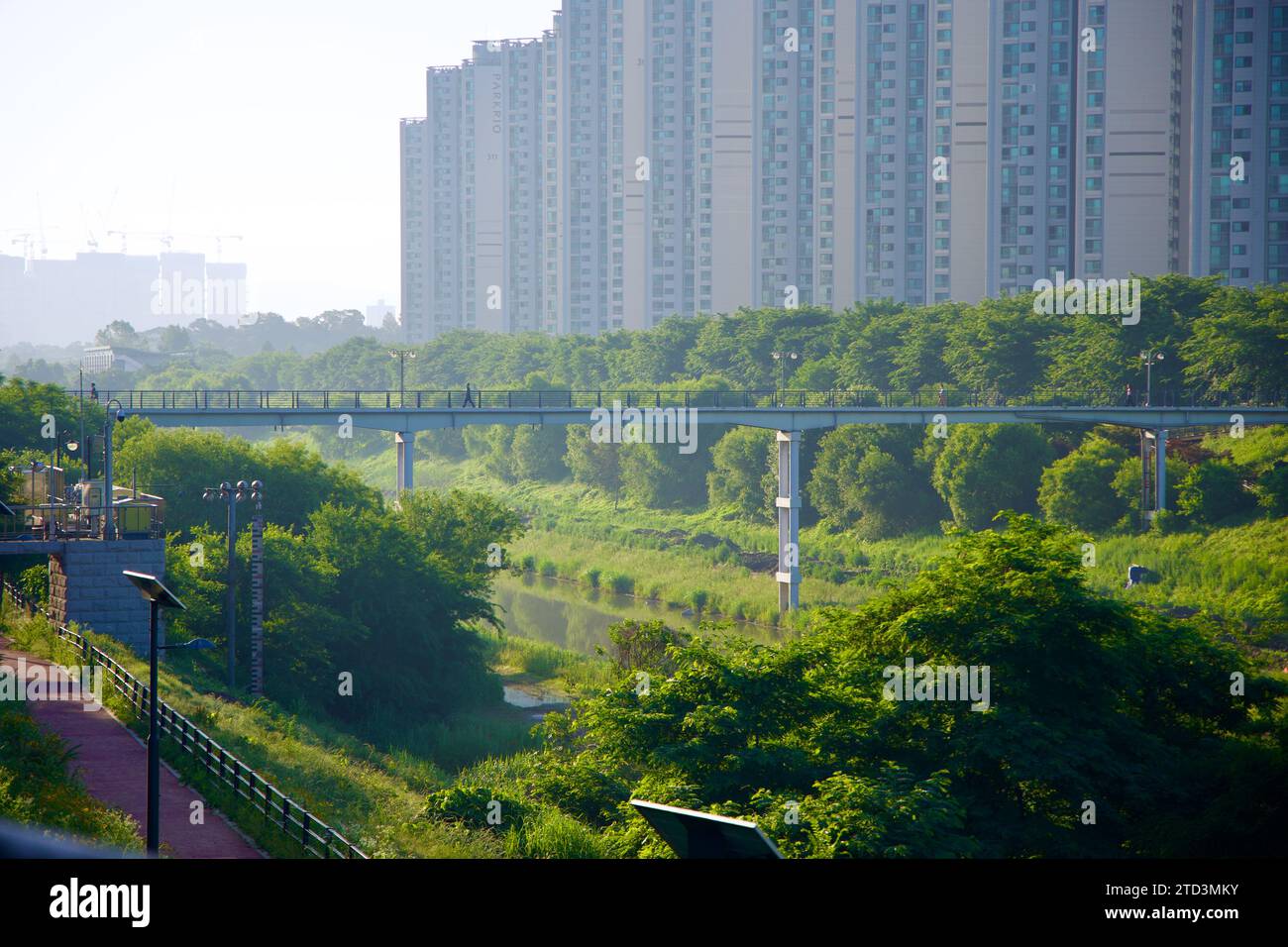 Seoul, Südkorea - 2. Juni 2023: Der Songpa Trail am frühen Morgen, mit einer hohen Brücke über einen Fluss und einer Mauer von Wohnungen in der BA Stockfoto