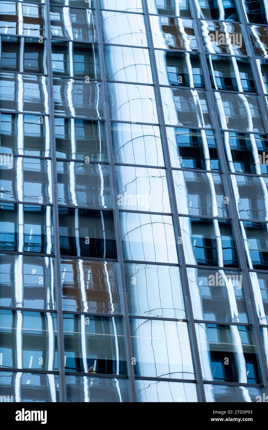 Abstraktes Mosaik aus geometrischen Formen ziert die Fassade des modernen Gebäudes und bildet gleichzeitig eine faszinierende Kulisse, die ein faszinierendes, sich wiederholendes Muster erzeugt Stockfoto