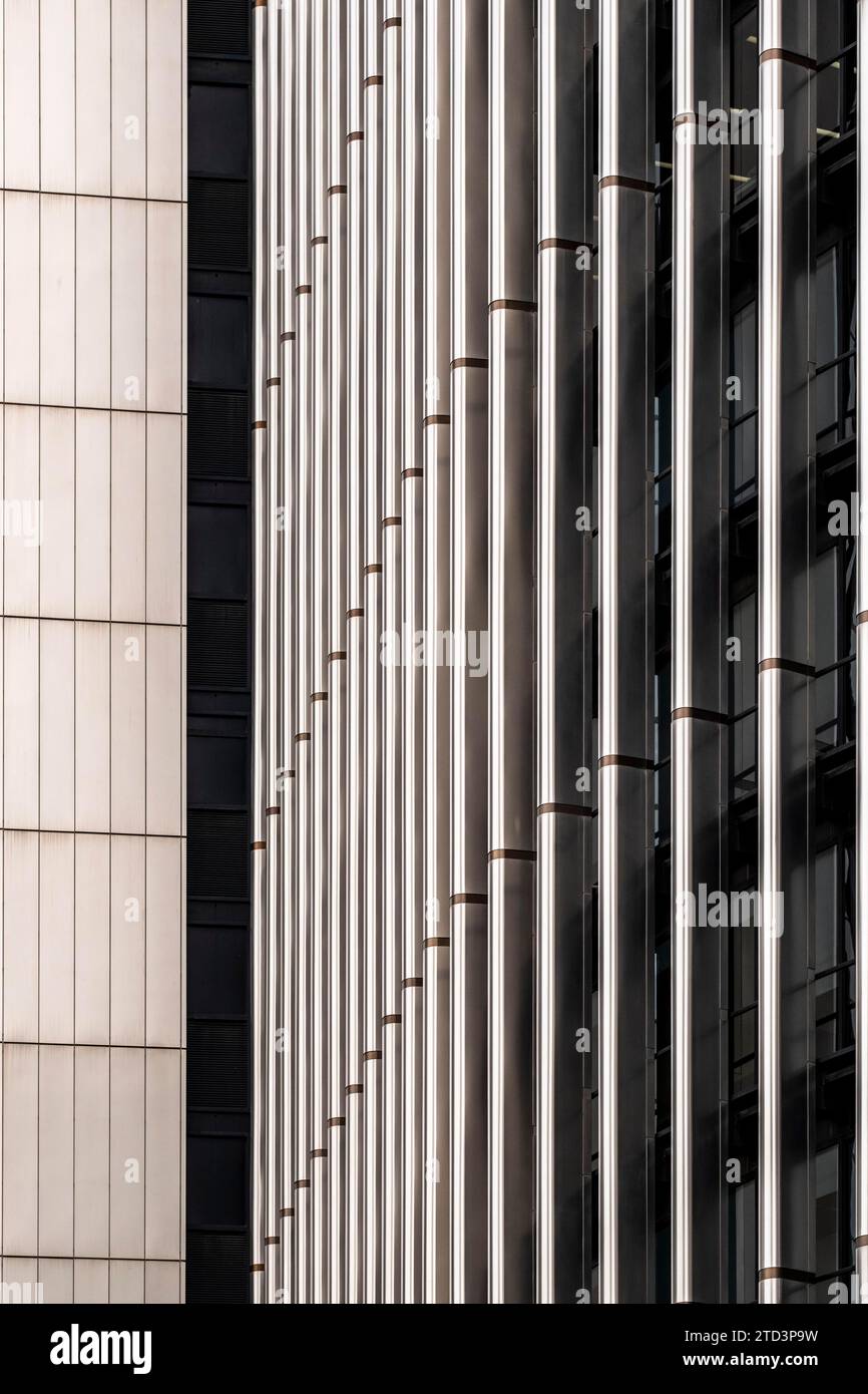Abstraktes Mosaik aus geometrischen Formen ziert die Fassade des modernen Gebäudes und bildet gleichzeitig eine faszinierende Kulisse, die ein faszinierendes, sich wiederholendes Muster erzeugt Stockfoto