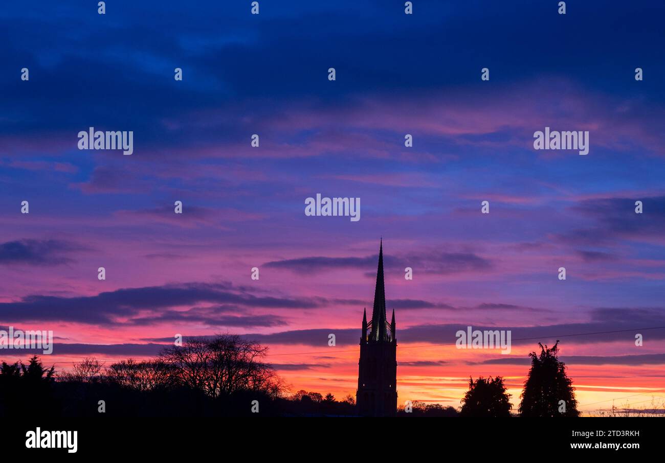 Dezember 2023 Louth, Lincolnshire, England. Ein dramatischer farbenfroher Sonnenuntergang hinter dem Turm der St. Jame’s Church in Louth, Lincolnshire. Hoch über der Landschaft der hübschen Marktstadt am Rande der Lincolnshire Wolds. Picture Phil Wilkinson / Alamy Live News Stockfoto