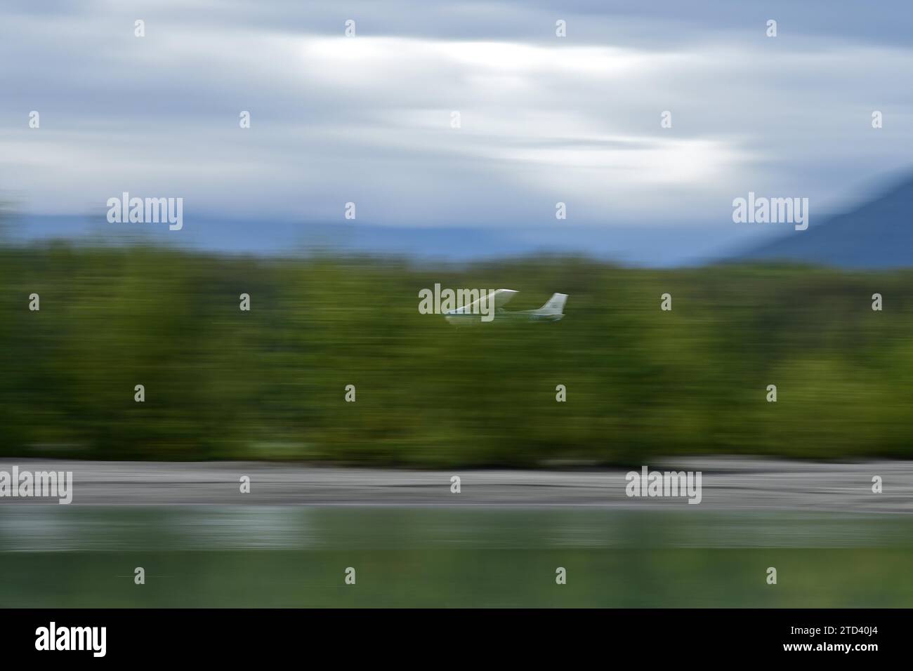 Ein Buschflugzeug fliegt mit hoher Geschwindigkeit nahe am Boden, Alaska Stockfoto