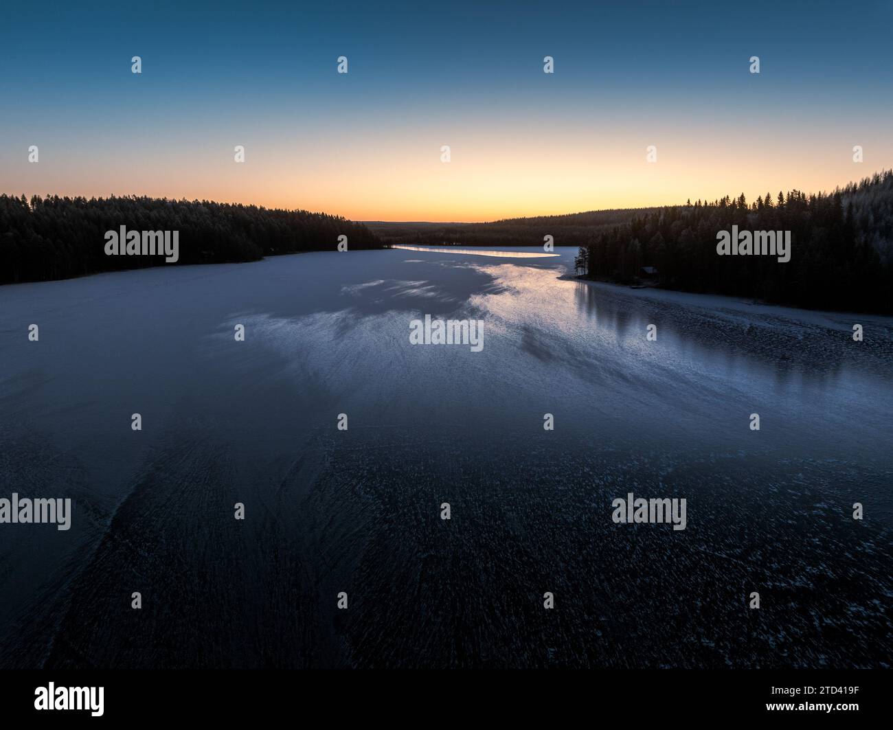 Wunderschöner Sonnenaufgang am eisbedeckten See im Winter Stockfoto