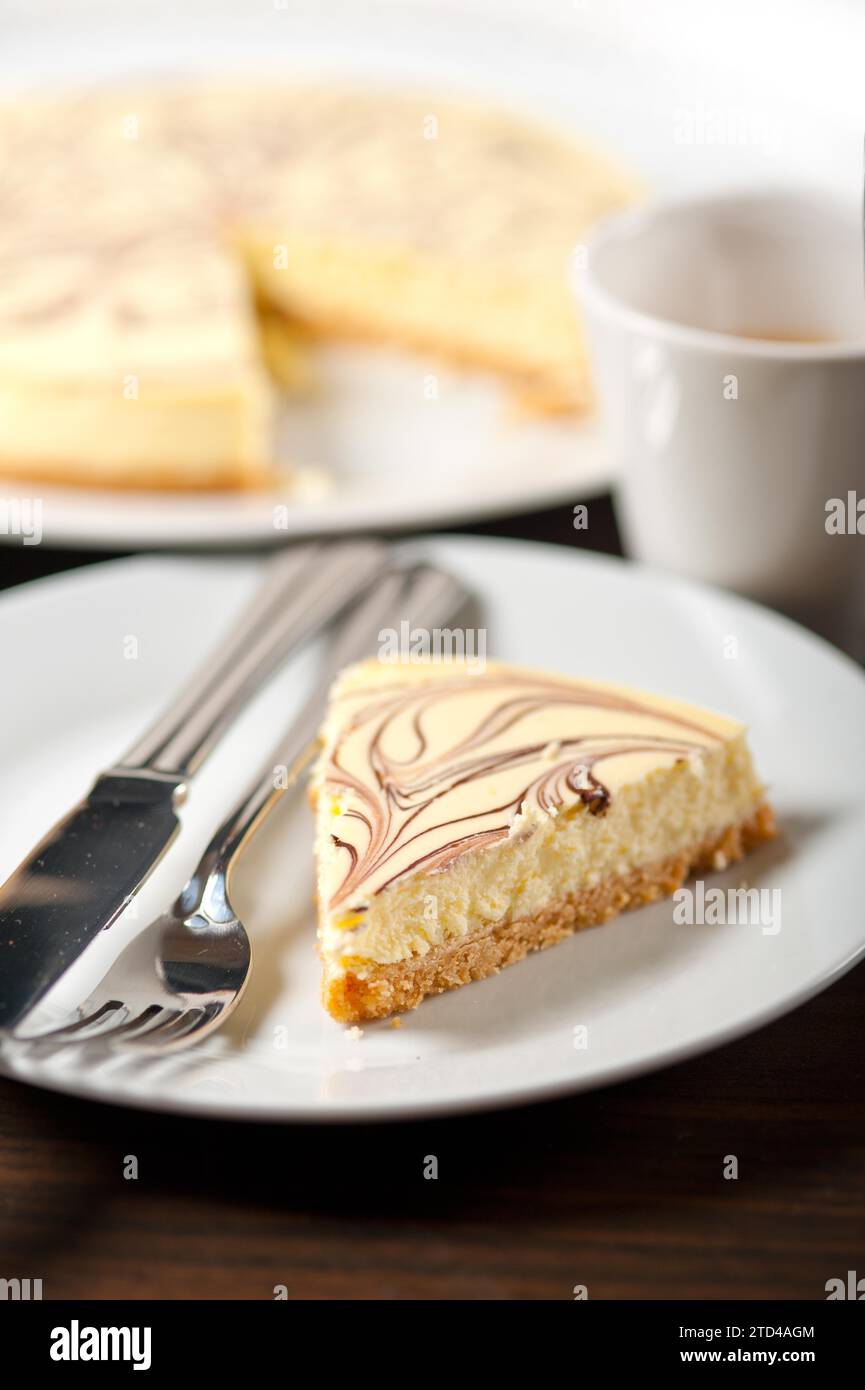 Frisch gebackener klassischer Käsekuchen mit Schokoladenbelag und Espresso-Kaffee, Lebensmittelfotografie Stockfoto