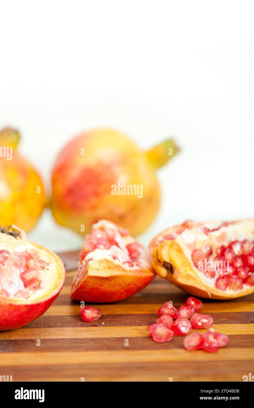 Frische Granatapfelfrucht auf Holz auf weißem Hintergrund, Lebensmittelfotografie Stockfoto