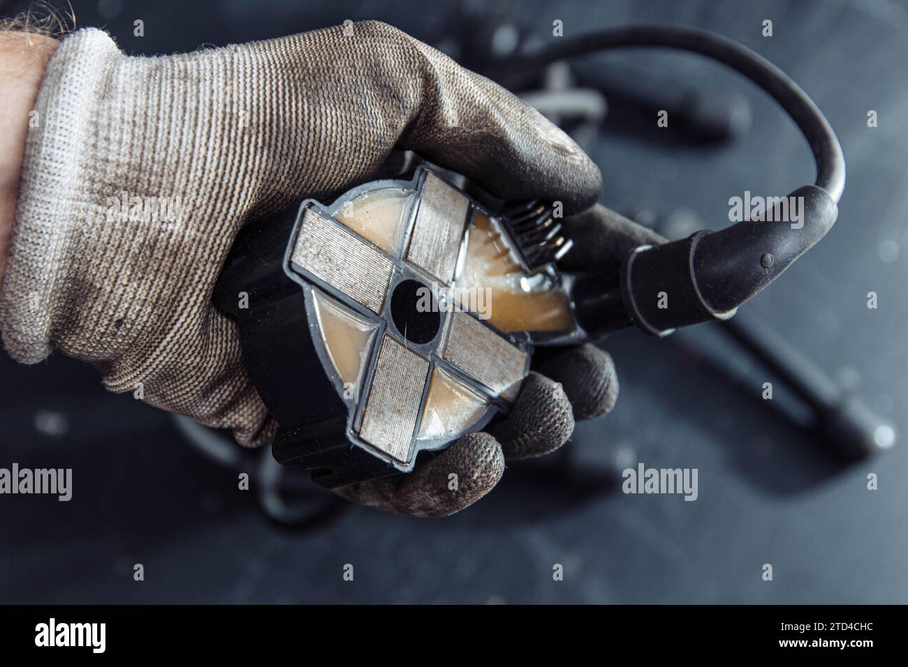 Motorzündungsspule in der Hand des Automechanikers Stockfoto