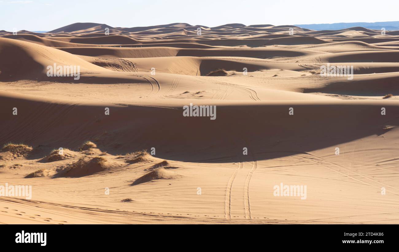 Sonnenuntergangslicht und Fußabdrücke in der Wüste von Merzouga in Marokko Stockfoto