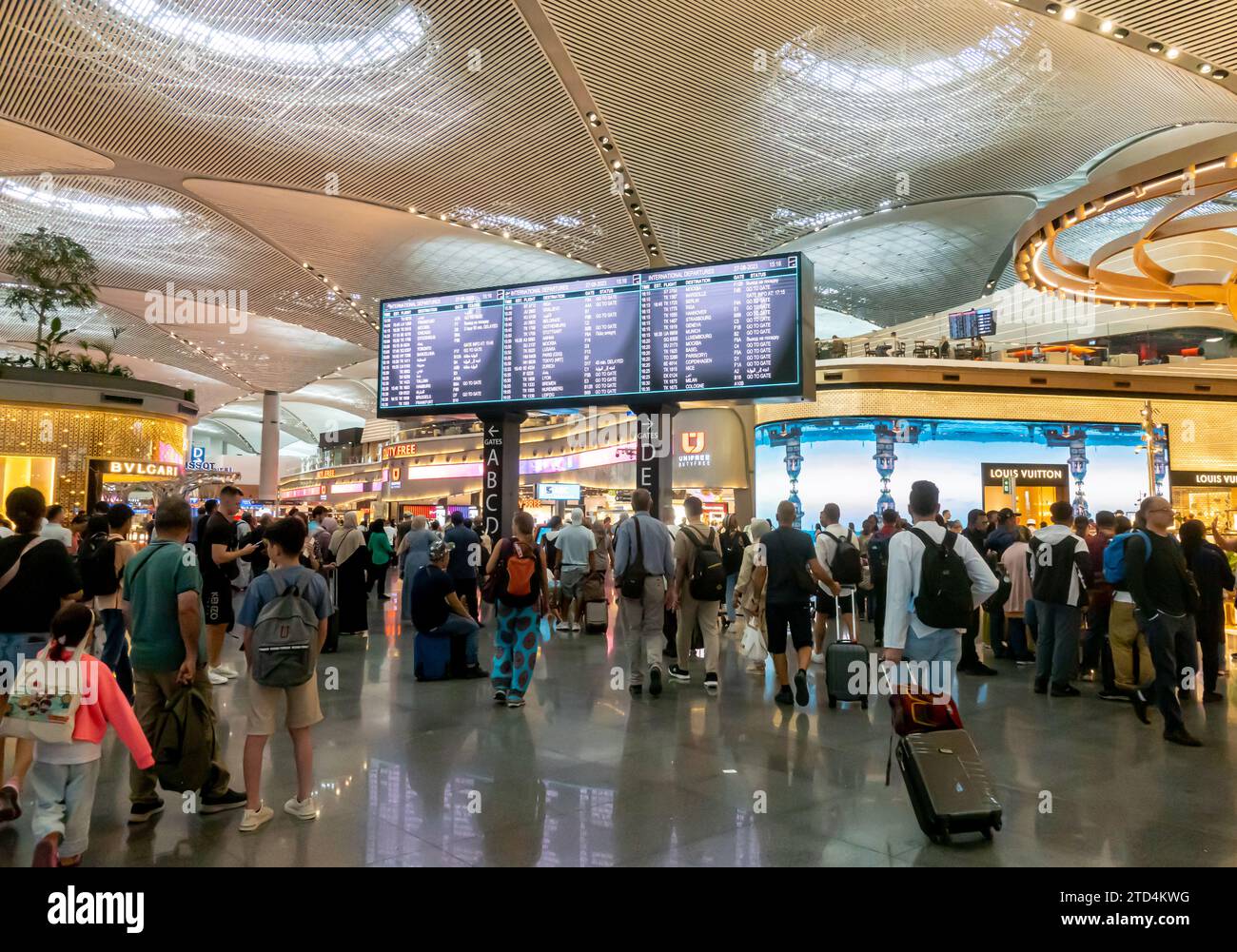 Touristen im internationalen Abflugplan Tableau am Flughafen Istanbul Havalimani - ist Airport Interior, Türkei Stockfoto