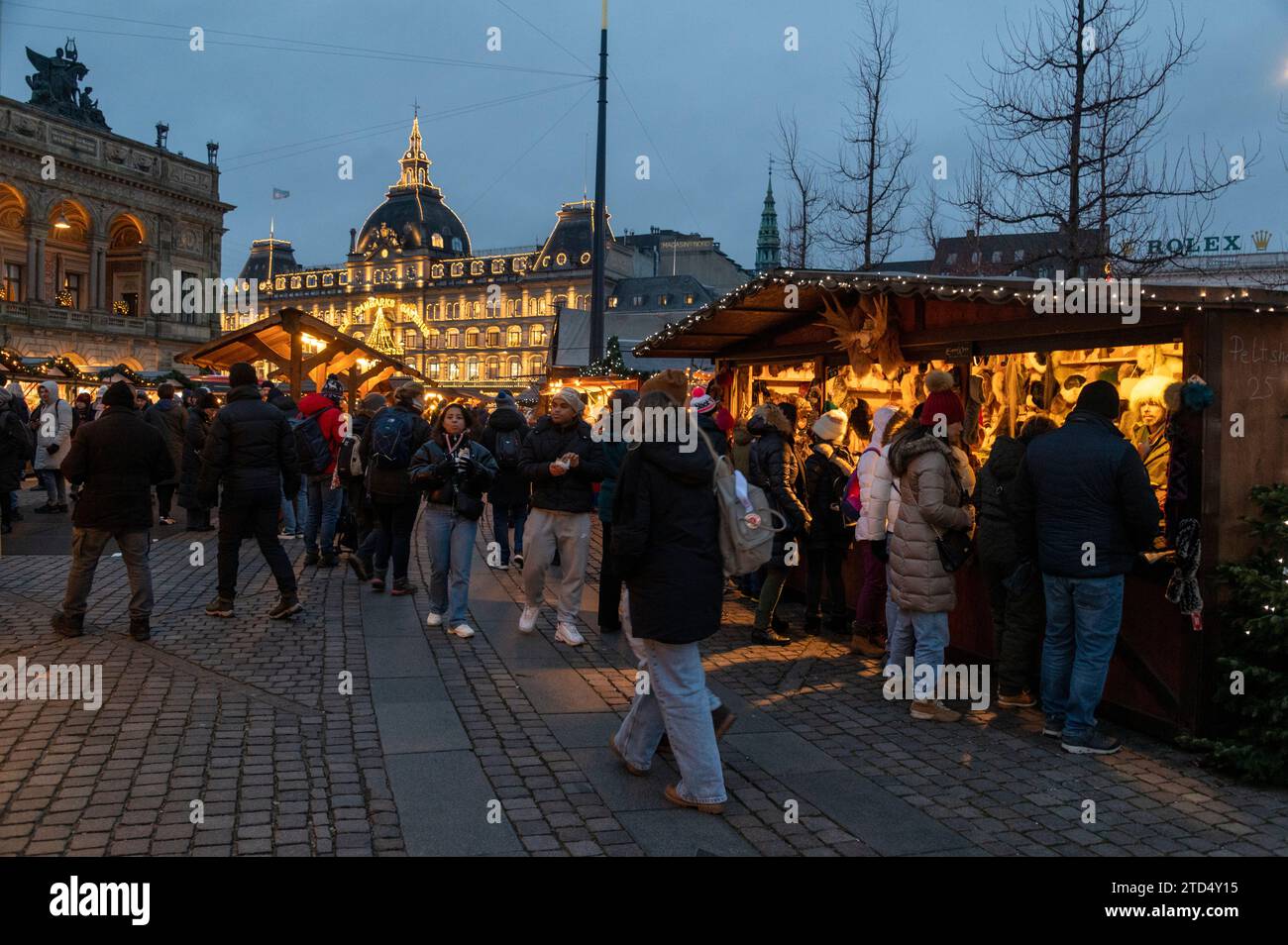 Eine geschäftige Weihnachtseinkaufsszene gesäumt von traditionellen deutschen Holzhütten, die aus Tirol importiert wurden, am Julemark (weihnachtsmarkt Stockfoto