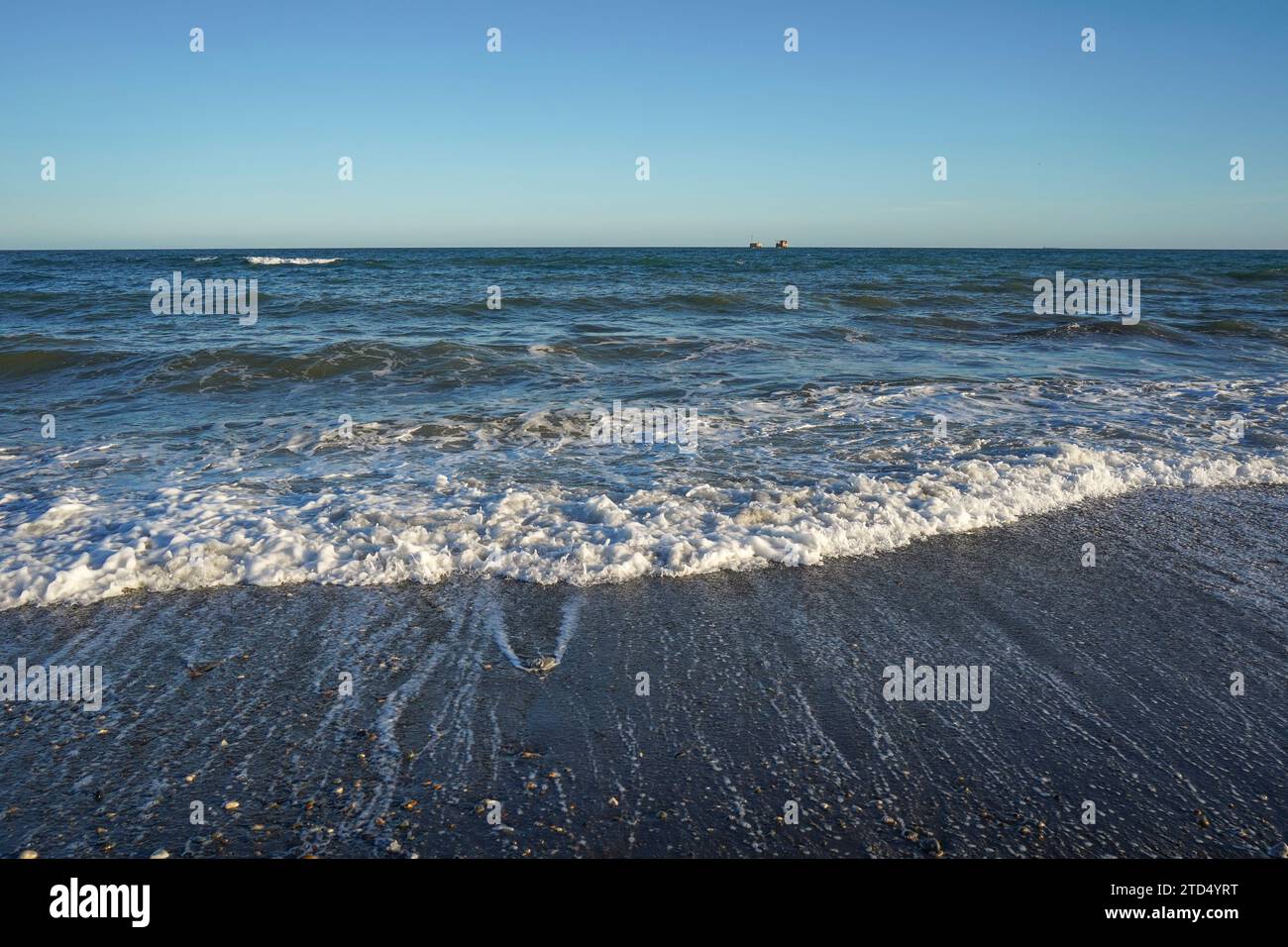 Die Meereszeitenwelle zieht sich am Strand zurück. Spanien. Stockfoto
