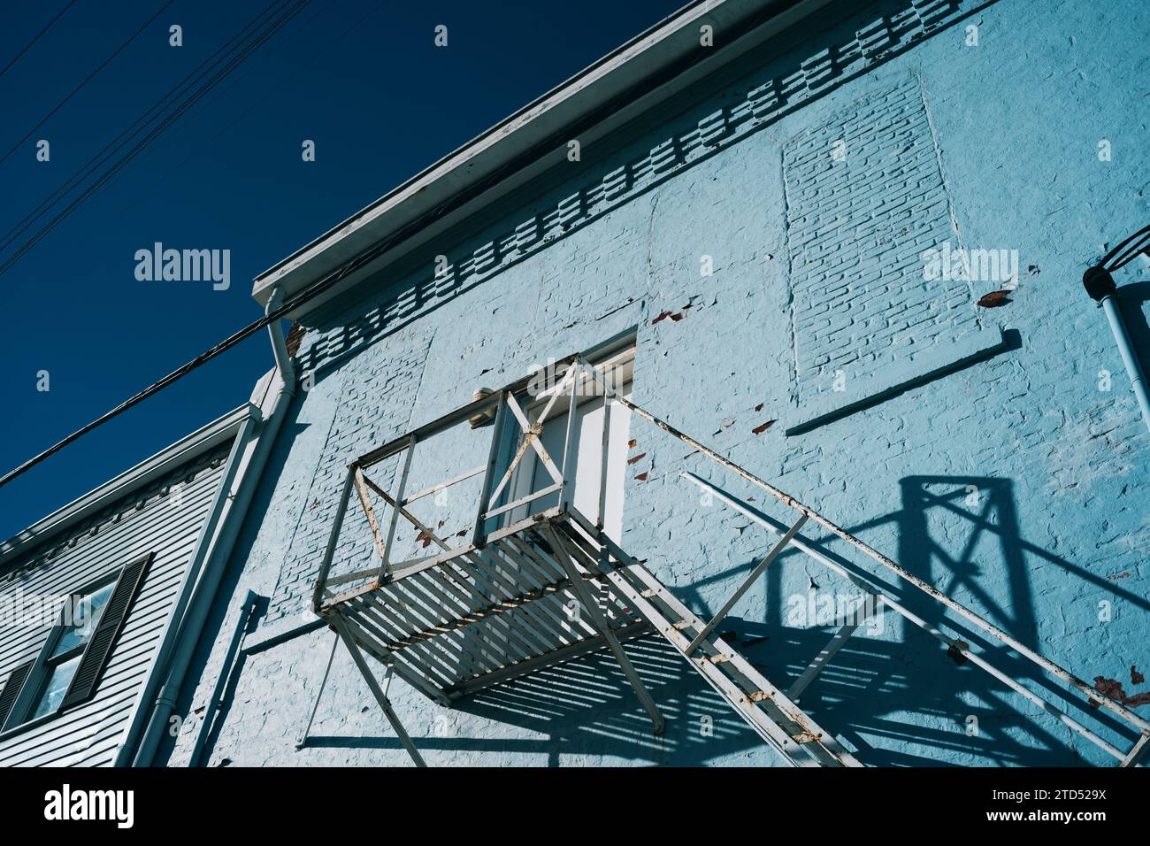 Altes Gebäude, blau gestrichen, mit einer Metalltreppe Stockfoto