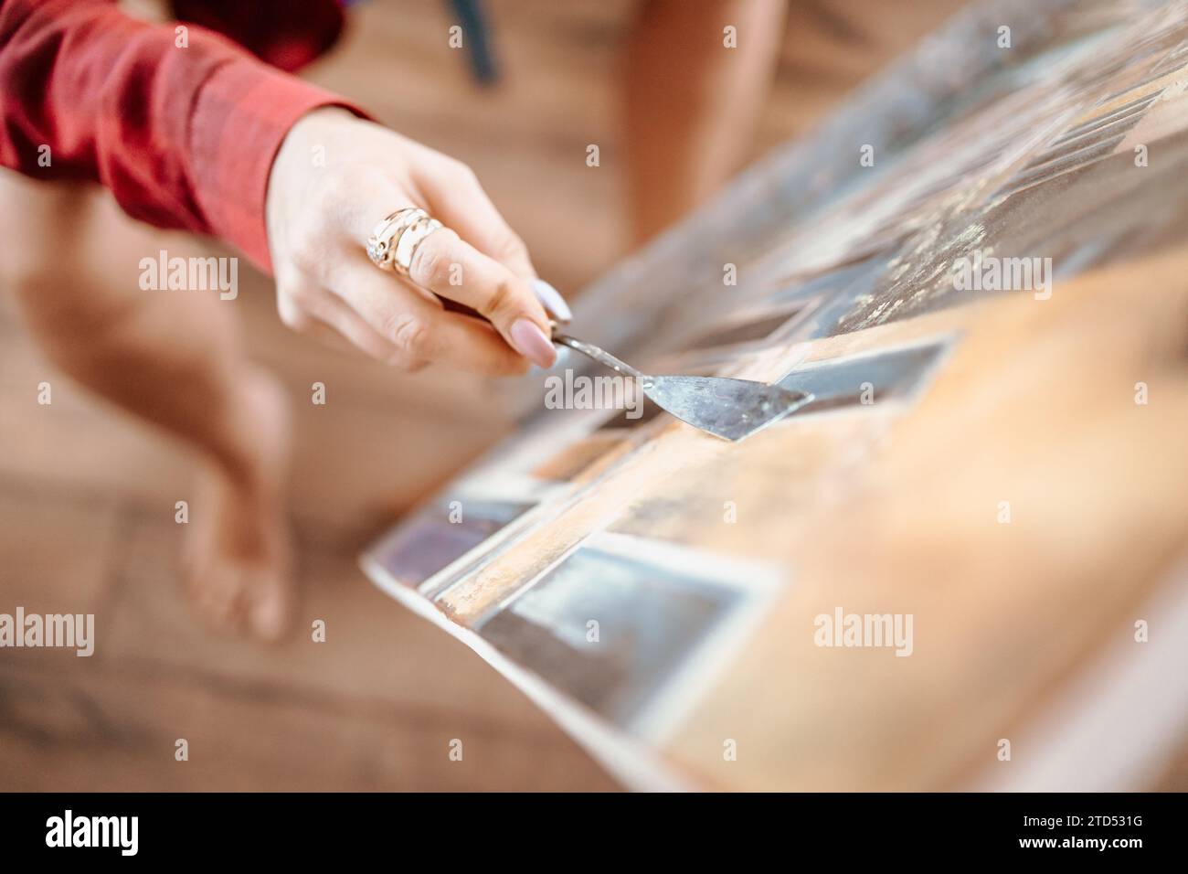 Junge, blonde Frau malte in ihrem Atelier Stockfoto