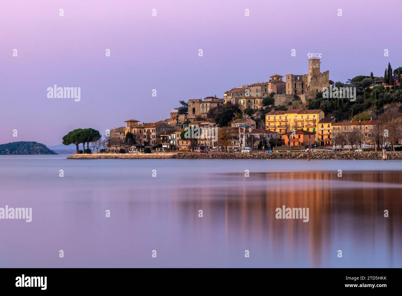 Das Dorf Passignano auf einem Hügel spiegelt sich im See Trasimeno in Umbrien, Italien Stockfoto