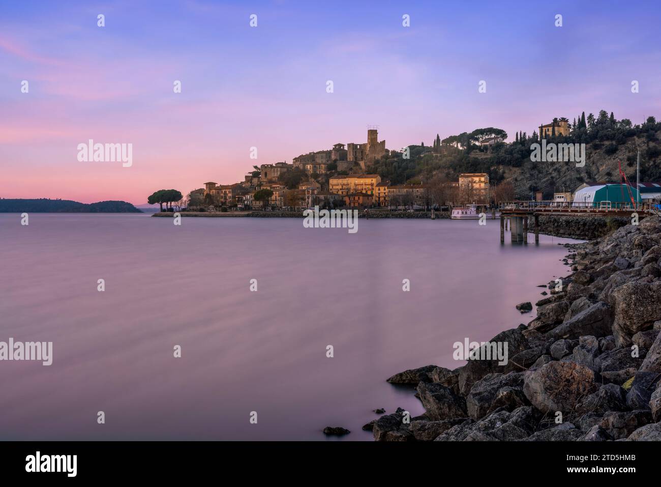 Das Dorf Passignano auf einem Hügel spiegelt sich im See Trasimeno in Umbrien, Italien Stockfoto