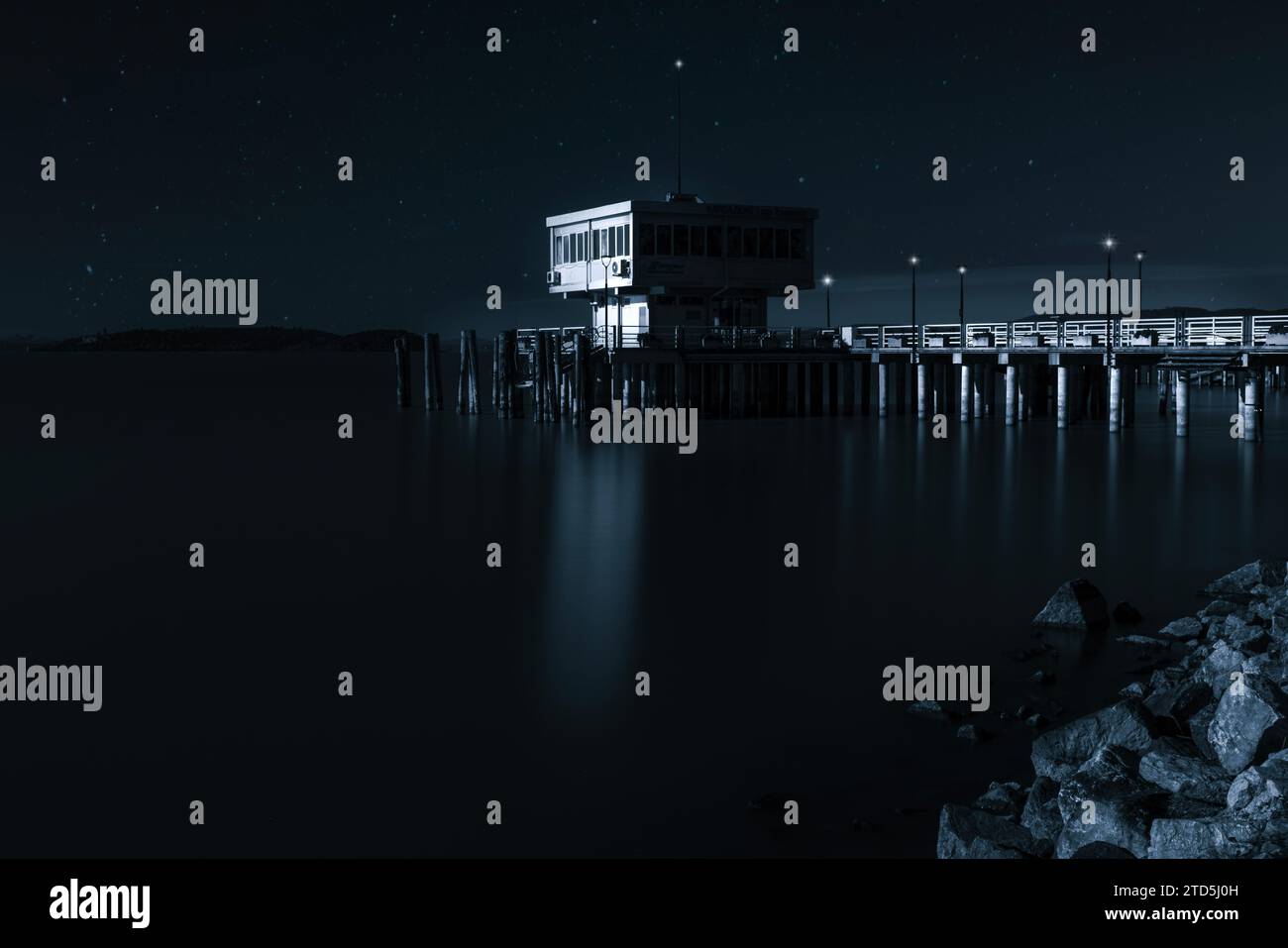 Das Dorf Passignano auf einem Hügel spiegelt sich im See Trasimeno in Umbrien, Italien Stockfoto