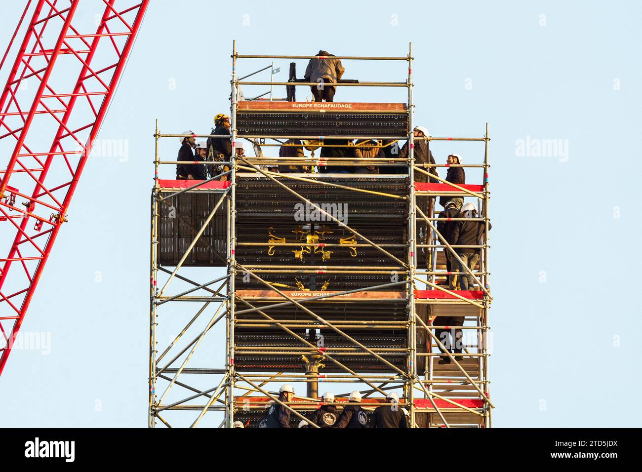 Der neue goldene Hahn mit Reliquien wird mit einem Kran angehoben und am 16. Dezember 2023 im Zentrum von Paris auf dem Turm der Kathedrale Notre Dame installiert. Der goldene Hahn, der vom Architekten Philippe Villeneuve entworfen wurde, enthält Reliquien, die von dem Brand gerettet wurden, der das Denkmal am 15. April 2019 traf, und ein Dokument mit den Namen der an seinem Wiederaufbau Beteiligten. Foto: Alexis Jumeau/ABACAPRESS.COM Stockfoto