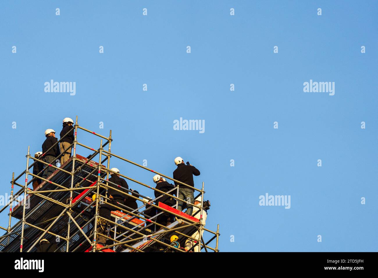 Der neue goldene Hahn mit Reliquien wird mit einem Kran angehoben und am 16. Dezember 2023 im Zentrum von Paris auf dem Turm der Kathedrale Notre Dame installiert. Der goldene Hahn, der vom Architekten Philippe Villeneuve entworfen wurde, enthält Reliquien, die von dem Brand gerettet wurden, der das Denkmal am 15. April 2019 traf, und ein Dokument mit den Namen der an seinem Wiederaufbau Beteiligten. Foto: Alexis Jumeau/ABACAPRESS.COM Stockfoto