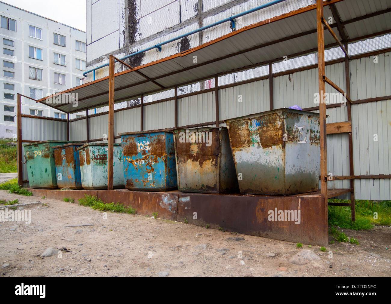 Alte Müllcontainer stehen auf einer ausgerüsteten Plattform im Innenhof des Hauses Stockfoto