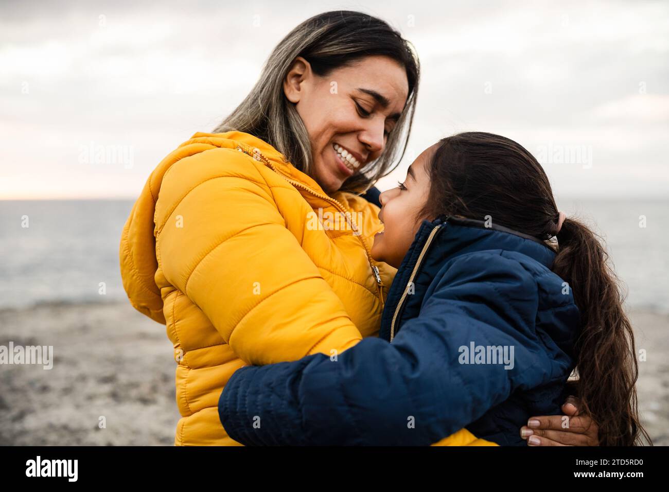 Glückliche lateinische Mutter mit Tochter, die an einem Wintertag zusammen genießt - Familie und Liebe Konzept Stockfoto