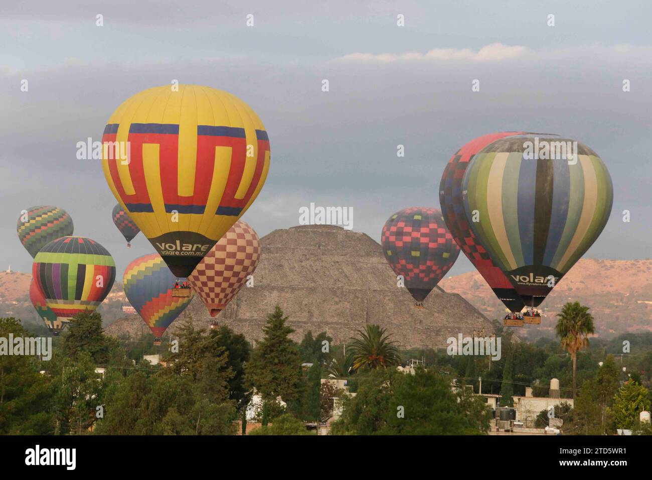 Teotihuacan, Mexiko. Dezember 2023. Heißluftballons verschiedener Firmen fliegen bei Sonnenaufgang im Pyramidenbereich von Teotihuacan, im Hintergrund kann man die große Pyramide der Sonne sehen. Credit: Luis E Salgado/Alamy Live News Credit: Luis E Salgado/Alamy Live News Stockfoto