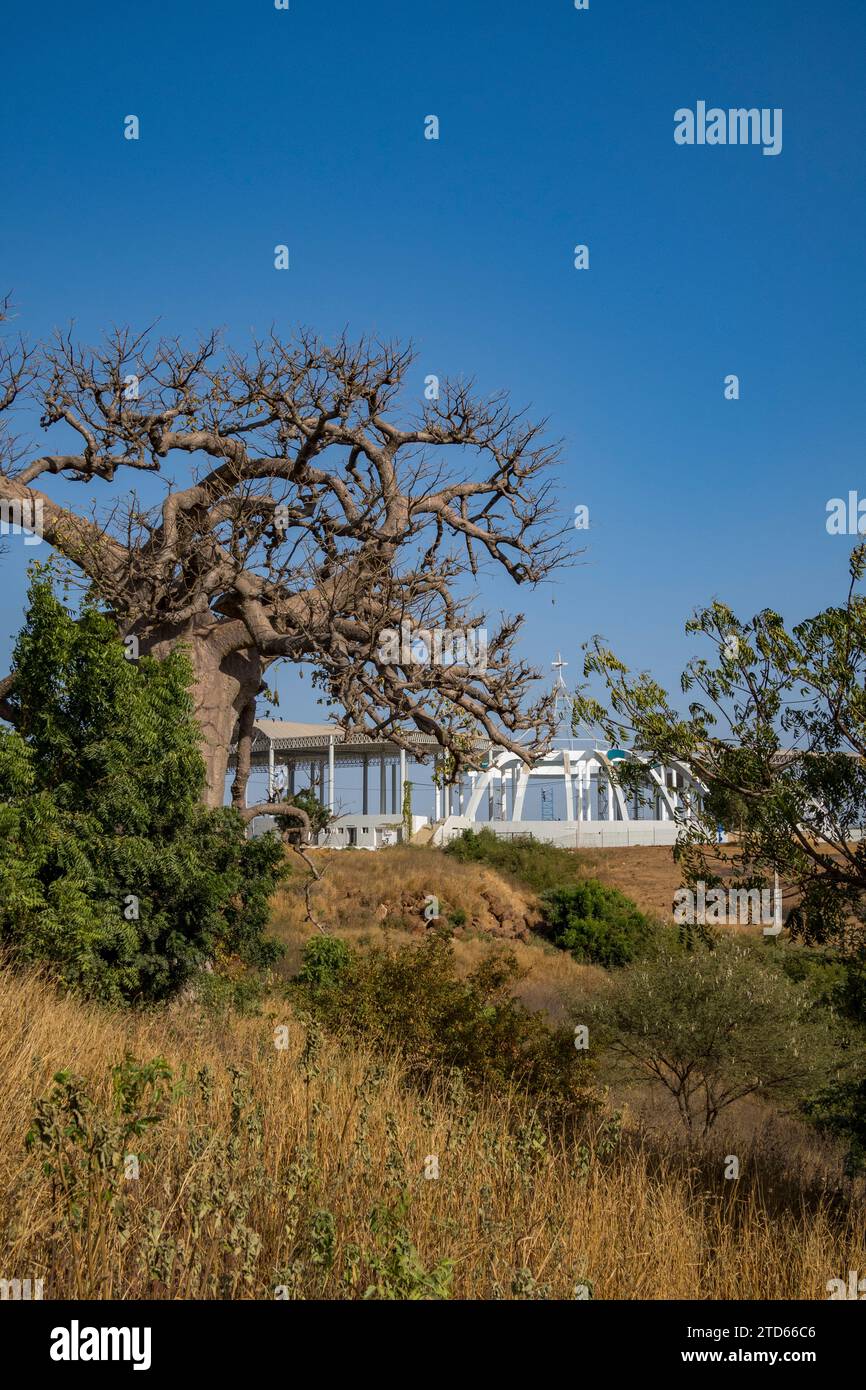 Sanctuaire Marial de Popenguine, der Marienschrein in Popenguine im Bau. Durch einen Baobab-Baum gesehen. Senegal, Afrika. 04.12.2023 Stockfoto