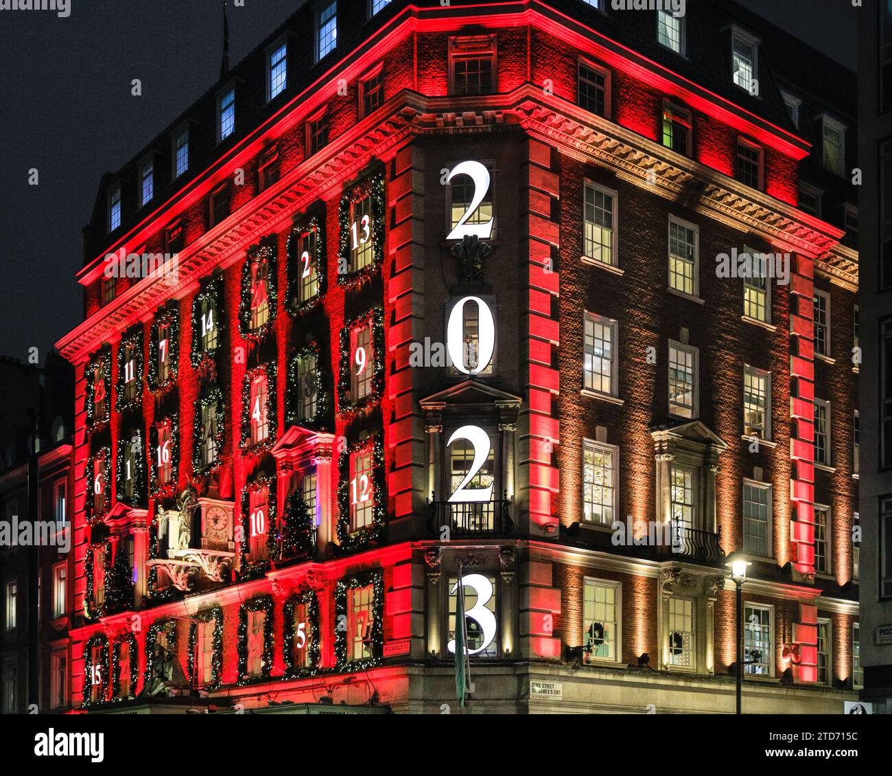 London, Großbritannien. Dezember 2023. Die jährlichen Fortnum & Mason Weihnachtsdekorationen sind hoch und zeigen wieder einmal einen riesigen Adventskalender auf der Fassade, in dem jedes Fenster eine kleine Tür darstellt und die Tage bis Weihnachten herunterzählt. Das Gebäude in Piccadilly ist rot beleuchtet und zieht große Touristenmassen an. Quelle: Imageplotter/Alamy Live News Stockfoto