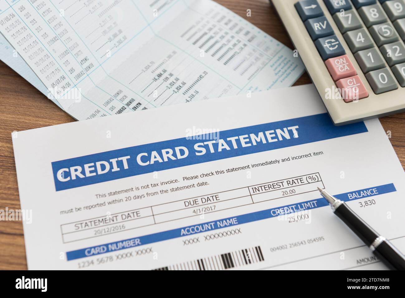 Kreditkartenauszug mit Bankkonto, Taschenrechner am Schreibtisch. Stockfoto