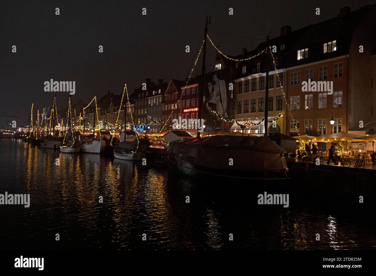Eine Flotte von mit Weihnachtslichtern geschmückten, vertäuten Booten auf dem Nyhavn-Kanal in Nyhavn, einem Viertel von Kopenhagen für seine berühmte breite Auswahl an Outdoor-/ Stockfoto