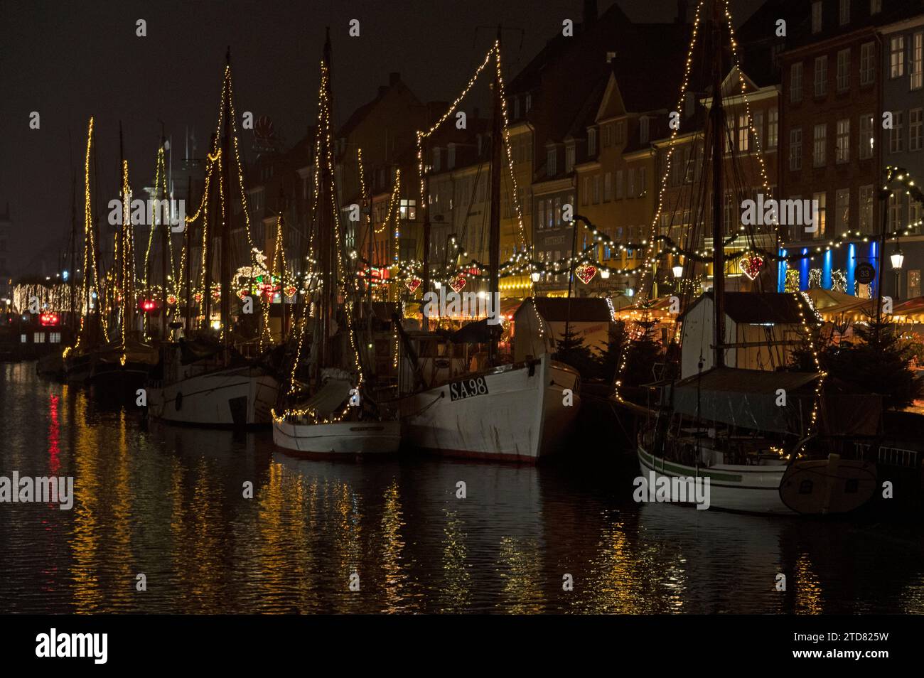 Eine Flotte von mit Weihnachtslichtern geschmückten, vertäuten Booten auf dem Nyhavn-Kanal in Nyhavn, einem Viertel von Kopenhagen für seine berühmte breite Auswahl an Outdoor-/ Stockfoto