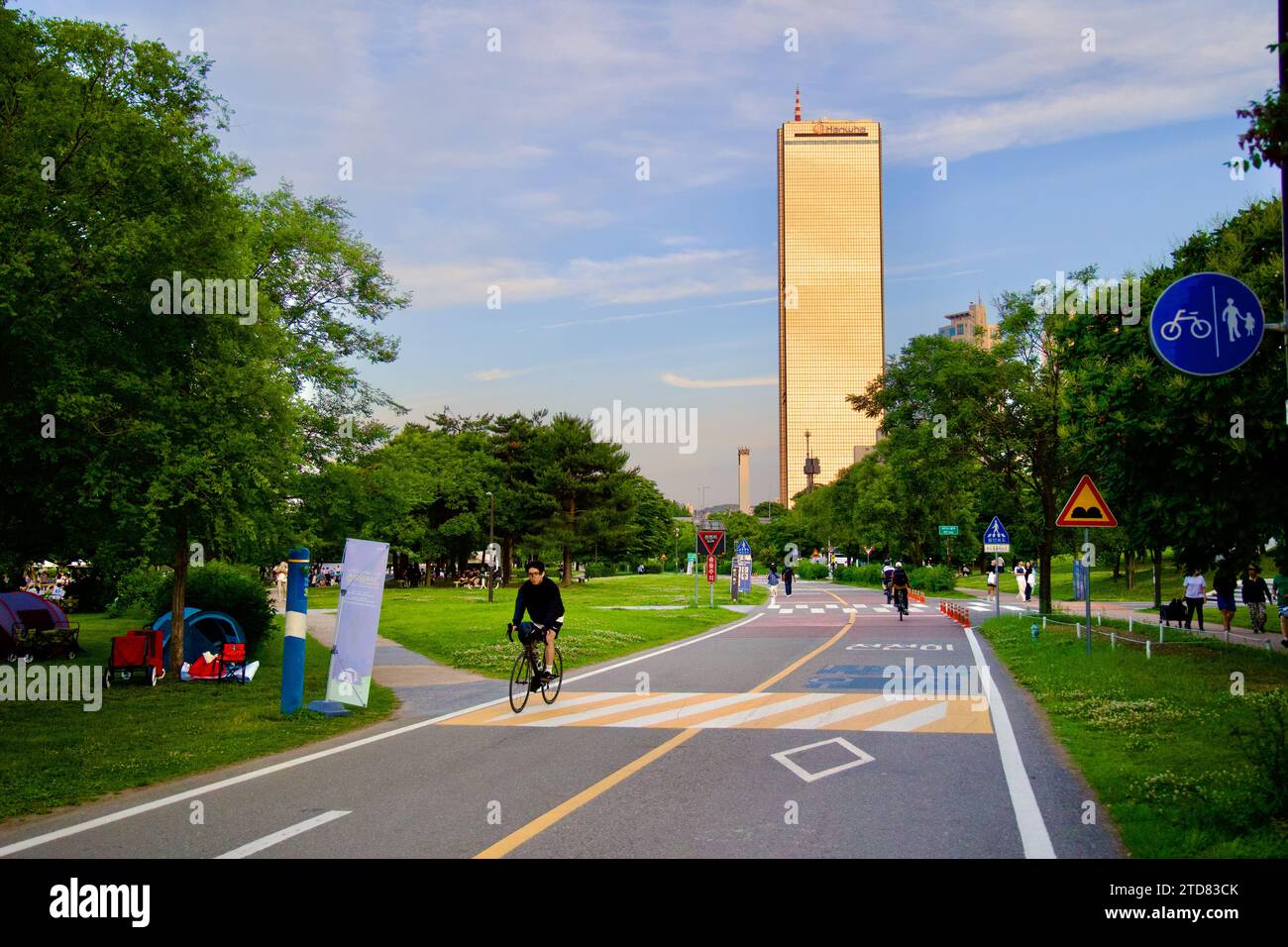 Seoul, Südkorea - 3. Juni 2023: Das berühmte Gebäude 63 mit seinen goldgetönten Fenstern steht hoch neben dem malerischen Radweg in Yeouido unter einem Keim Stockfoto