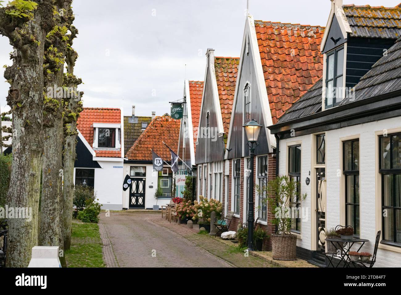 Dorf Oosterend. Kerkstraat (Kirchenstraße) mit typisch niederländischen Häusern unter bewölktem Himmel. Texel, Nordholland, Niederlande. Stockfoto