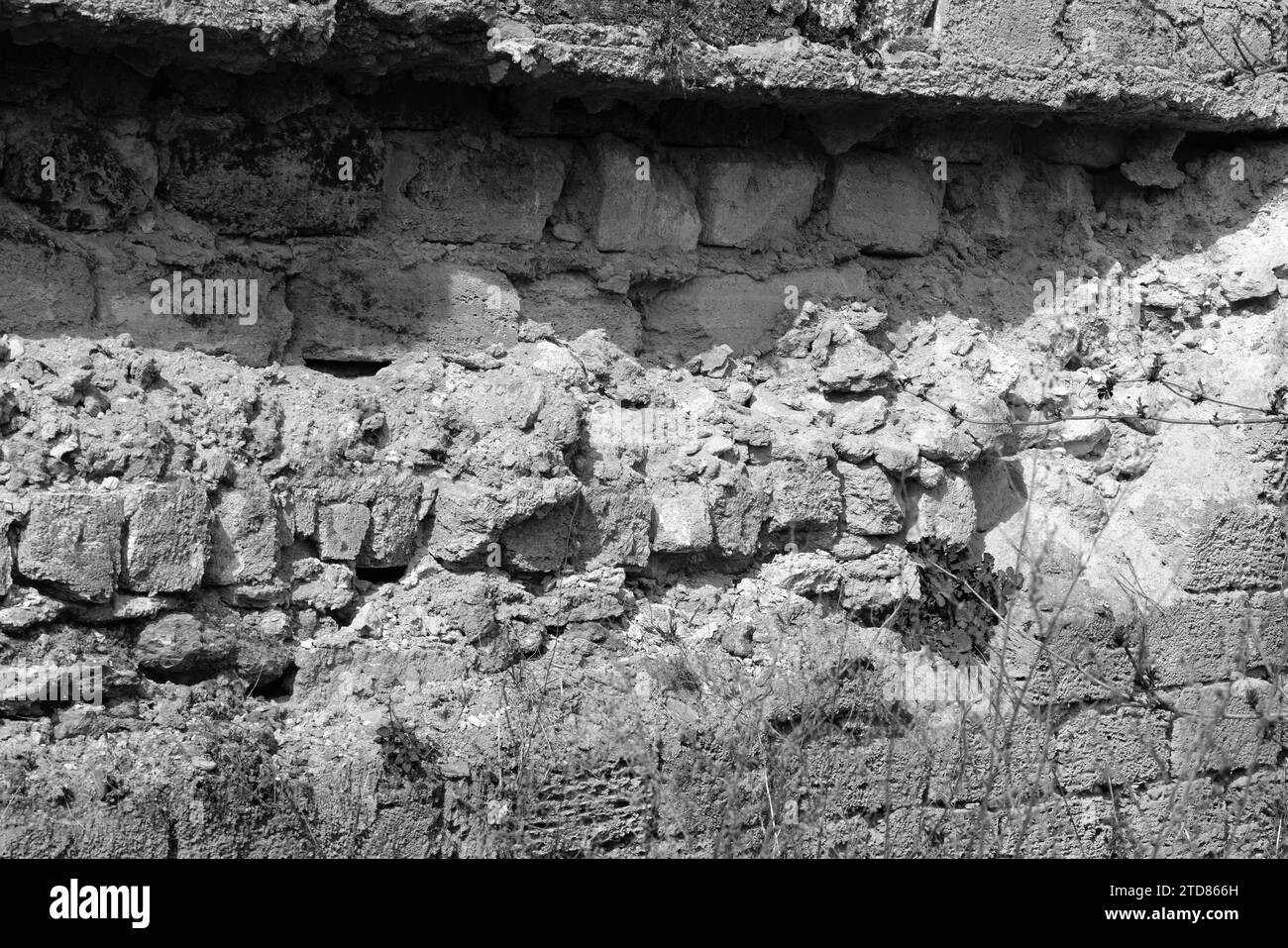 Eine kaputte Mauer eines alten Hauses in der Nähe, Spuren von Klimaverwitterung. Risse in der Wandstruktur mit Loch. Ziegelsteinmauer des Gebäudes Shell Rock House destro Stockfoto Eine kaputte Mauer eines alten Hauses in der Nähe, Spuren von Klimaverwitterung. Risse in der Wandstruktur mit Loch. Ziegelsteinmauer des Gebäudes Shell Rock House destro Stockfoto