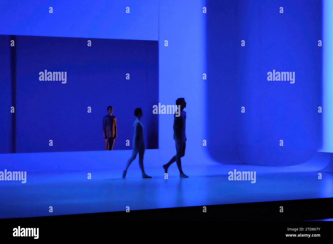 Drei Tänzer, einer getrennt in einem großen Fenster, zwei in Silhouette, die Bühne ein Wash von blauem Licht. Das Australian Ballet; Chroma, Sydney Opera House Stockfoto