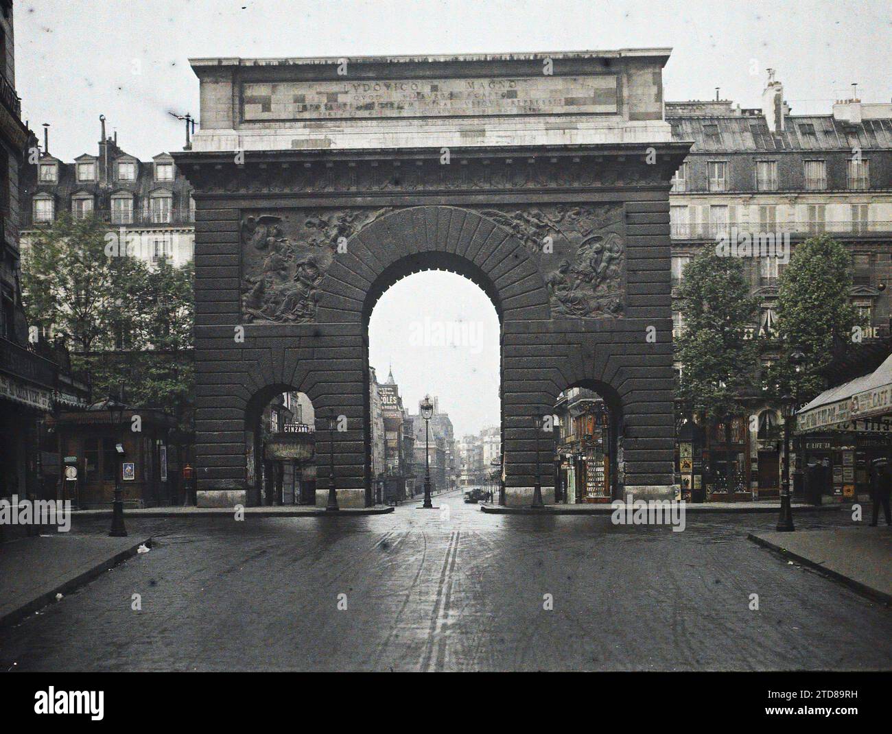 Paris (10. Arr.), Frankreich Porte St-Martin, Blick von der Rue du Faubourg St-Martin, Wirtschaftstätigkeit, HD, Kunst, Inschrift, Informationen, Gehäuse, Architektur, Straßenlaterne, Straßenlaterne, Boutique, Geschäft, existiert in High Definition, Skulptur, kommerzielle Inschrift, Basrelief, Architekturinschrift, Gedenkinschrift, Statueninschrift, Straße, Bezirk, Tür, Arc, Arcade, Arch, Showcase, Display, Laden, Marquise, skulpturale Dekoration, Frankreich, Paris, Porte St Martin, Arrondissement X, 07/1914 - 31.07.1914, Passet, Stéphane, Fotograf, Autochrome, Foto, Glas, Autochrome, Foto Stockfoto