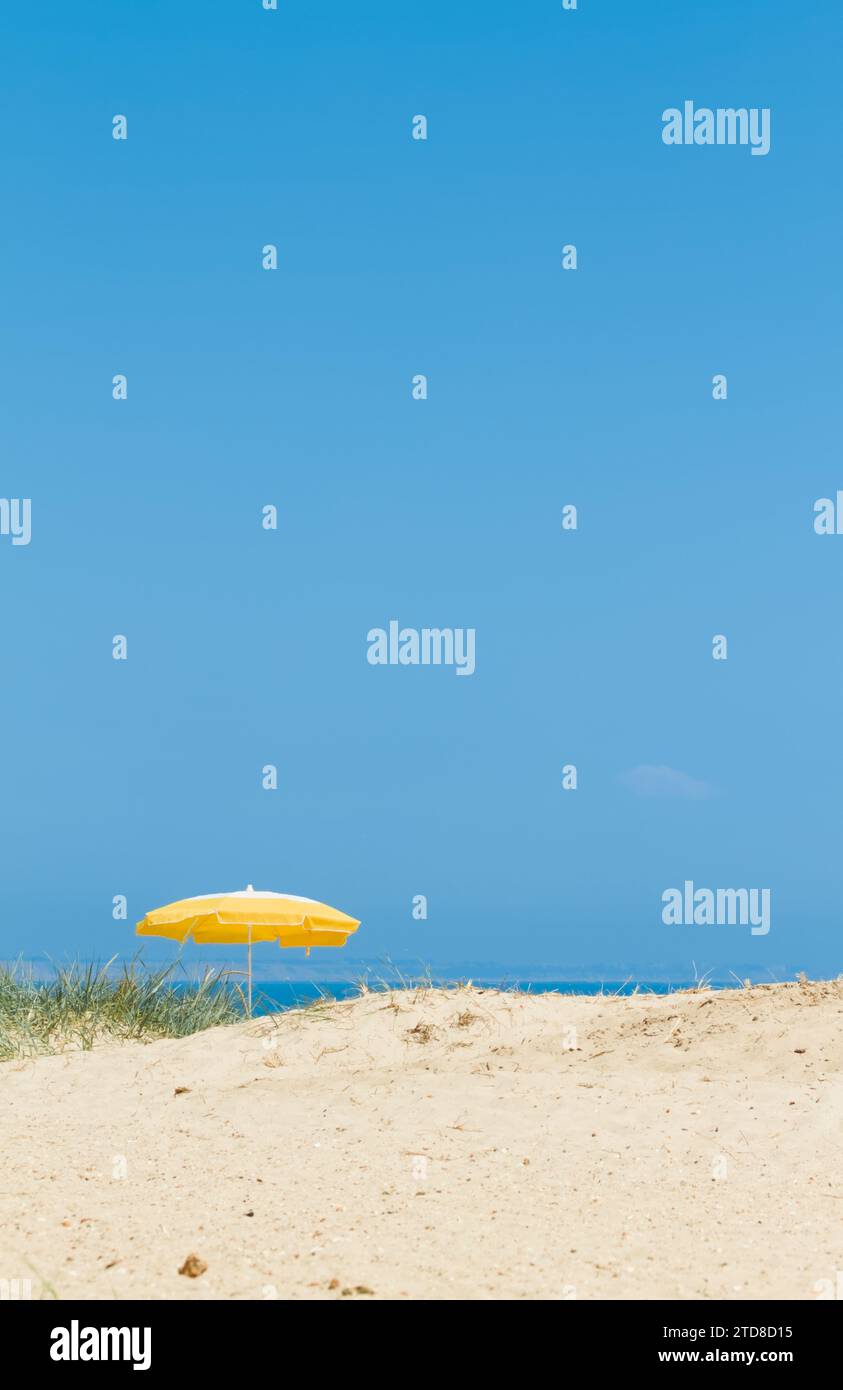 Single Yellow Umbrella in the Sand Dunes on A Beach an einem englischen Sommertag, Mudeford Spit, Hengistbury Head, Christchurch UK Stockfoto