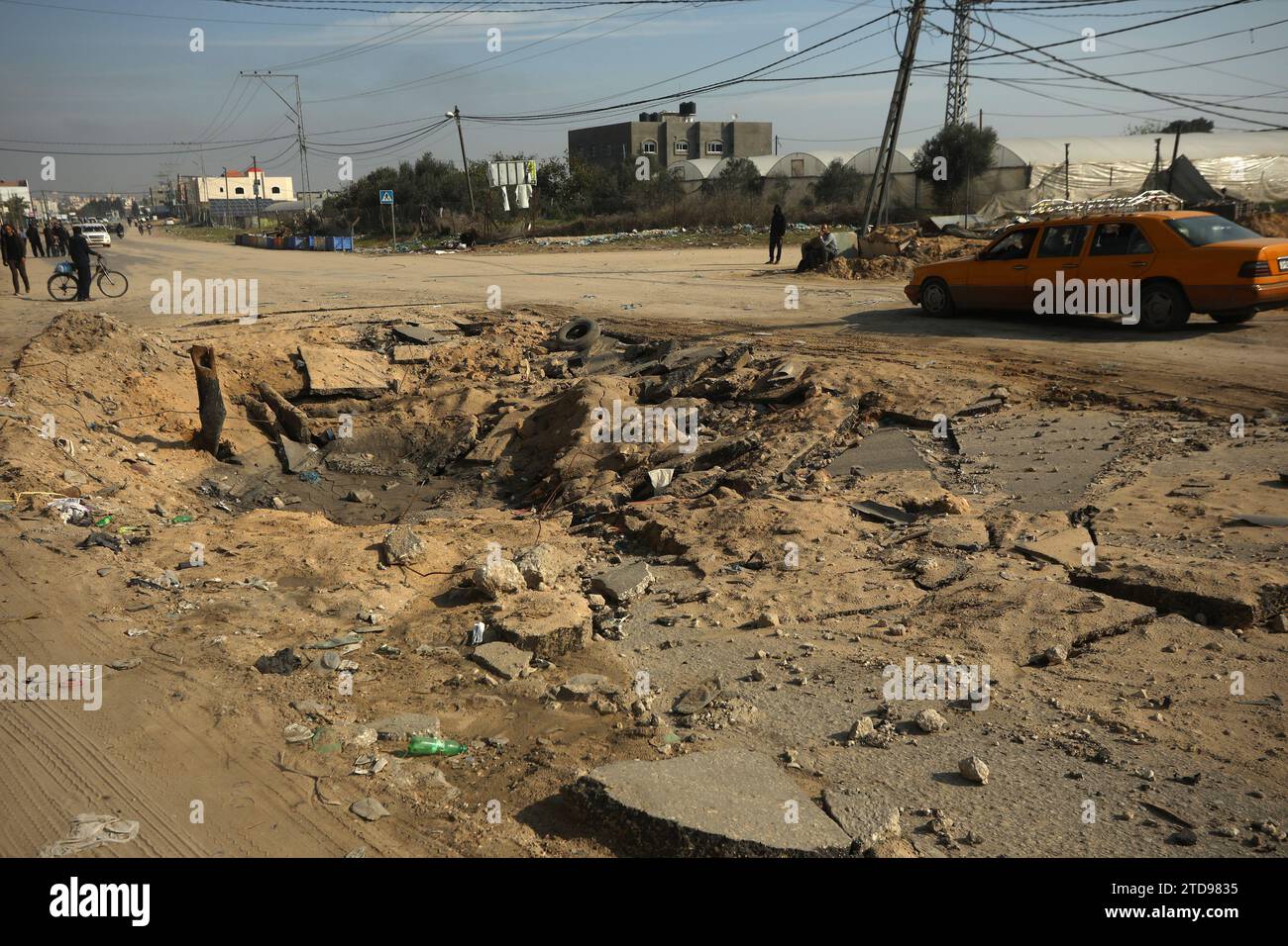 Khan Yonis, Gaza. Dezember 2023. Autos Palästinenser fahren über einen schmalen Abschnitt der Salah Al-DIN-Straße, um einem Krater zu entgehen, der durch israelische Bombenangriffe verursacht wurde, Khan Yunis im südlichen Gazastreifen, während eines israelischen Streiks. Am sonntag, 17. Dezember 2023. Während der anhaltenden Kämpfe zwischen Israel und der palästinensischen Gruppe Hamas. Der Internetzugang und das Telefonnetz waren über den Gazastreifen komplett durchgeschnitten. Foto: Ismael Mohamad/UPI Credit: UPI/Alamy Live News Stockfoto