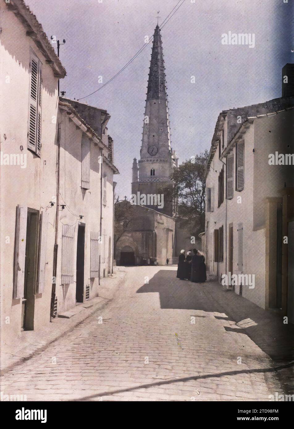 Ars-en-Ré, Ile-de-Ré, Frankreich Kirche Saint-Etienne, Blick von der Rue Thiers, Menschen, Wohngebäude, Architektur, Kirche, Insel, Frau, Uhr, Glockenturm, ländliche Architektur, Wohnung, gepflasterte Straße, Straße, Bezirk, religiöse Architektur, Frankreich, Ile-de-Ré, Ars-en-Ré, Kirche, Ars-en-Ré, 08/1920 - 31.08.1920, Cuville, Fernand, 1920-1921 - Charente, Gironde, Basse-Pyrénées, Hautes Pyrénées - Fernand Cuville, Autochrome, Foto, Glas, Autochrome, Foto, positiv, Vertikal, Format 9 x 12 cm Stockfoto