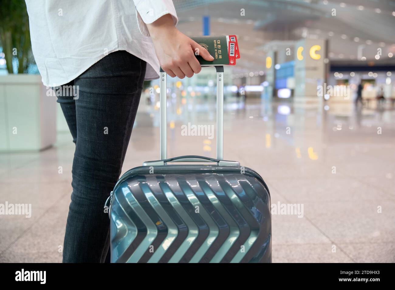 Eine Frau steht und wartet, nachdem sie die Ticketausstellung am Flughafen abgeschlossen hat Stockfoto