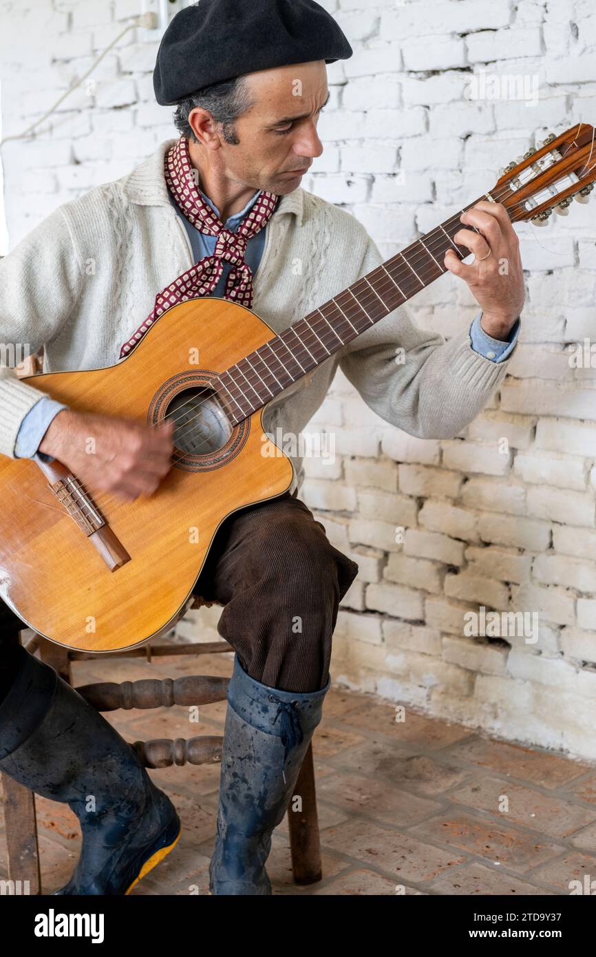 Argentinien, San Antonio de Areco, El Ombu, Gaucho spielt Gitarre. Stockfoto