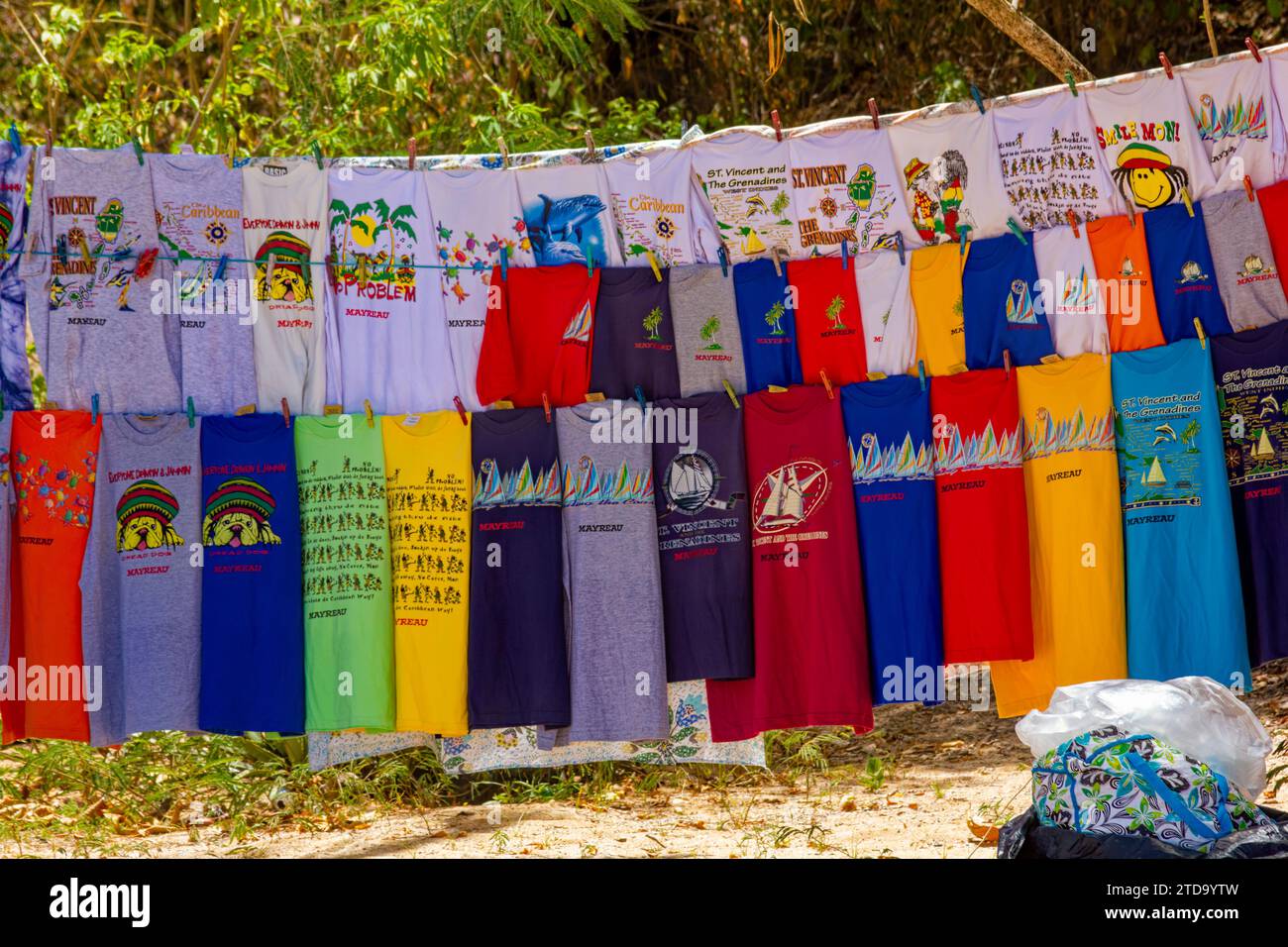 Farbenfrohe T-Shirts zum Verkauf an einem Karibikstrand: Salt Whistle Bay, Mayreau, Saint Vincent und die Grenadinen. Stockfoto