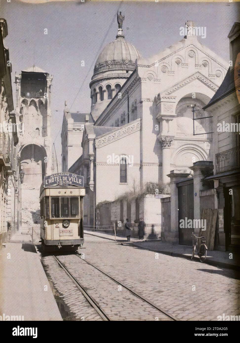Touren, Frankreich die Straßenbahnlinie C, Rue Descartes mit dem Charlemagne-Turm und der Basilika Saint-Martin, Transport, Persönlichkeit, Religion, Natur, Umwelt, Alltag, Wohnraum, Architektur, Kirche, Radverkehr, Erdbeben, religiöse Persönlichkeit, Christentum, Naturphänomen, Glockenturm, Straßenszene, Saint, Tramway, Straße, Bezirk, Dilapidation, unhygienische Bedingungen, Kuppel, Kuppel, Giebel, Schienenverkehr, religiöse Architektur, Frankreich, Tours, der entkernte Charlemagne-Turm, Blick von der Rue Descartes und den neuen St. Martin-Basilika, Tours, 03/04/1928 - 03/04/1928, Léon, Auguste, Stockfoto
