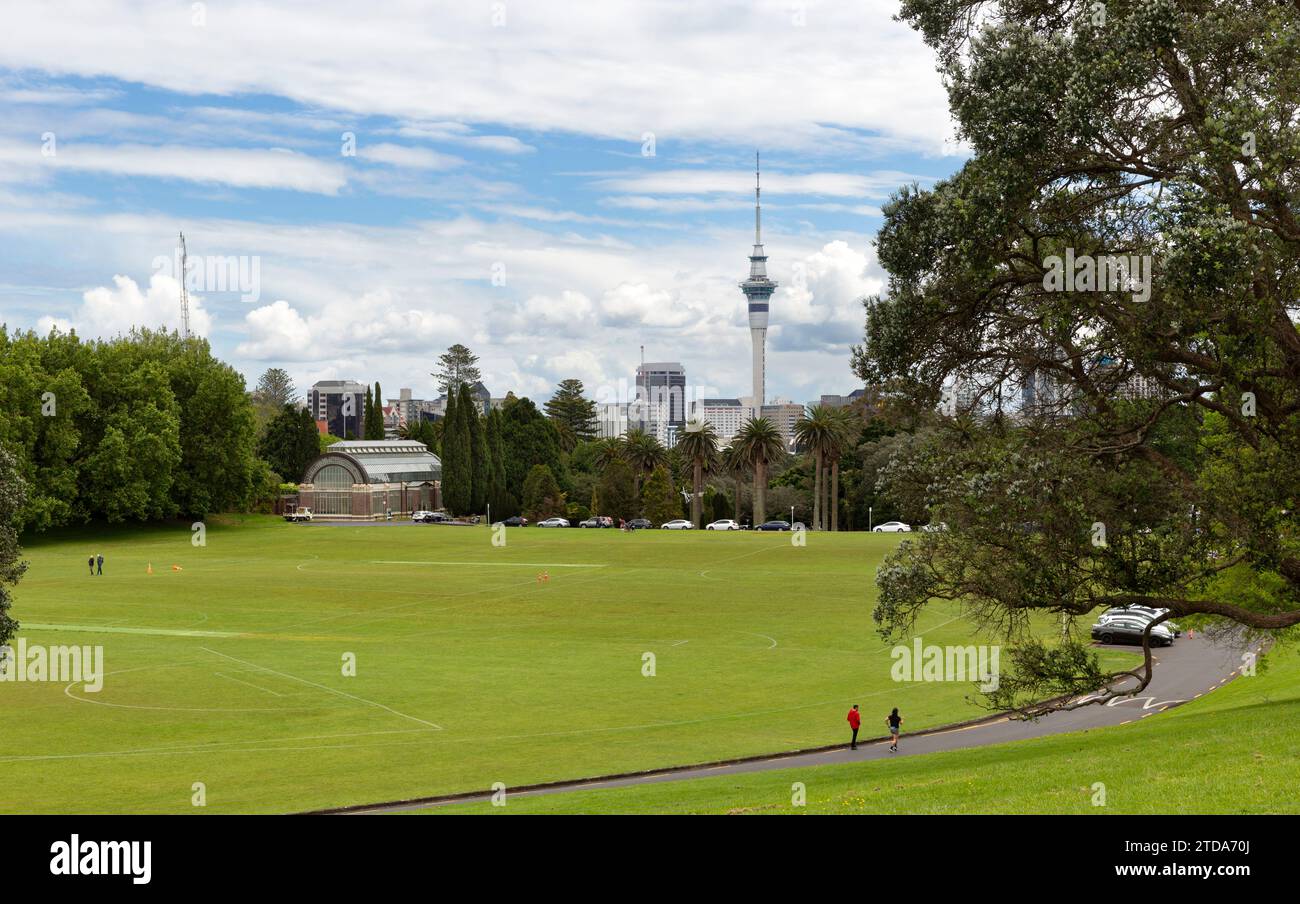 Sportplätze in Auckland, Neuseeland, mit einem Gewächshaus für botanische Gärten in den Auckland Domain Wintergarden und dem Sky Tower Gebäude Stockfoto