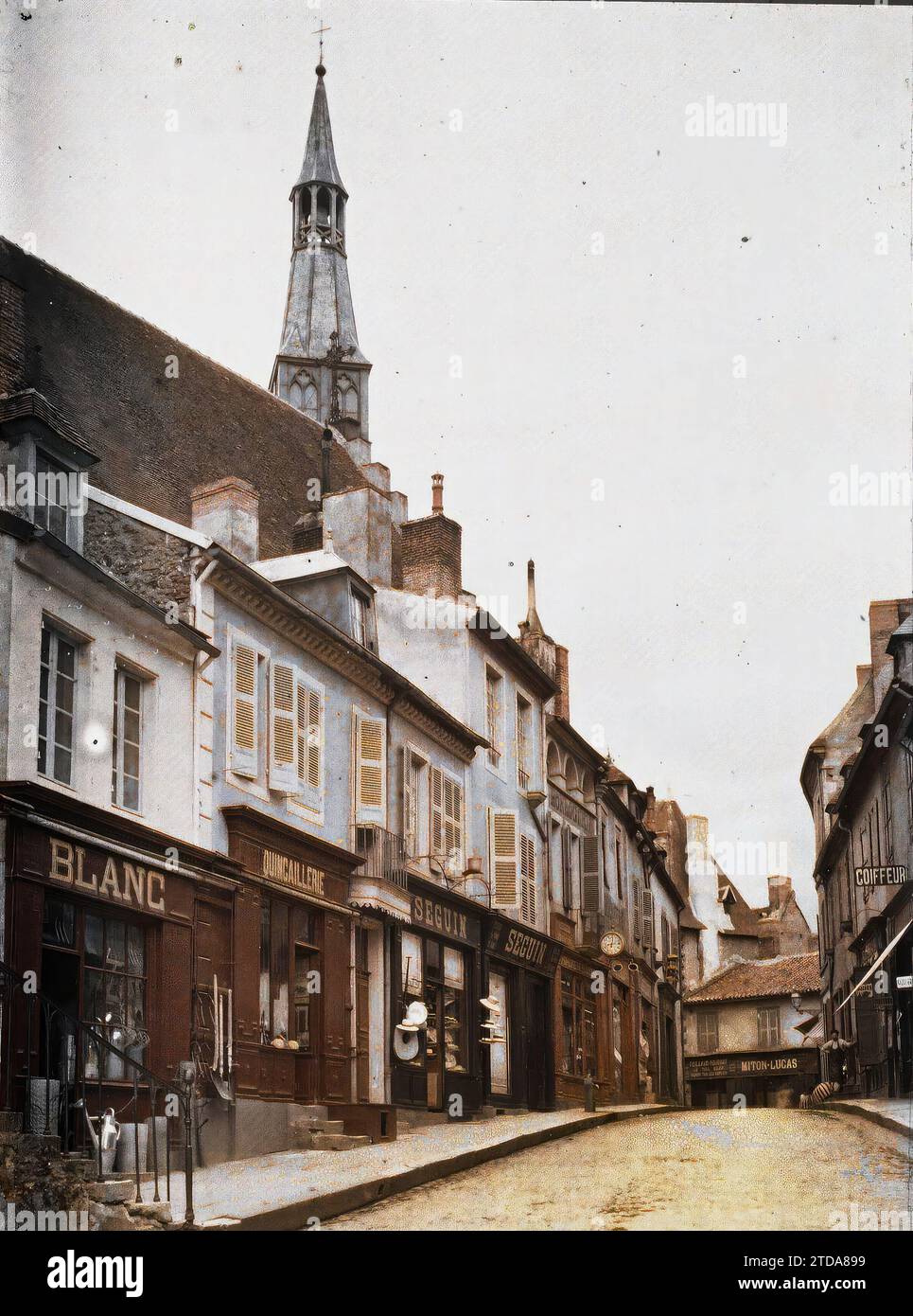 Saint-Pourcain-sur-Sioule, Allier, Frankreich Rue de Metz, Glockenturm der Kirche Sainte-Croix, Wirtschaftstätigkeit, HD, Registrierung, Informationen, Gehäuse, Architektur, Geschäft, Geschäft, existiert in High Definition, Glockenturm, kommerzielle Inschrift, Straße, Bezirk, Schaufenster, Ausstellung, Frankreich, St. Pourcain, Saint-Pourcain-sur-Sioule, 08/1911 - 08.06.1911, Léon, Auguste, Fotograf, 1911 - Centre de la France Auvergne Bourgogne - Auguste Léon - (17. Juli - 6. August), Autochrome, Foto, Glas, Autochrome, Foto, positiv, Vertikal, Format 9 x 12 cm Stockfoto